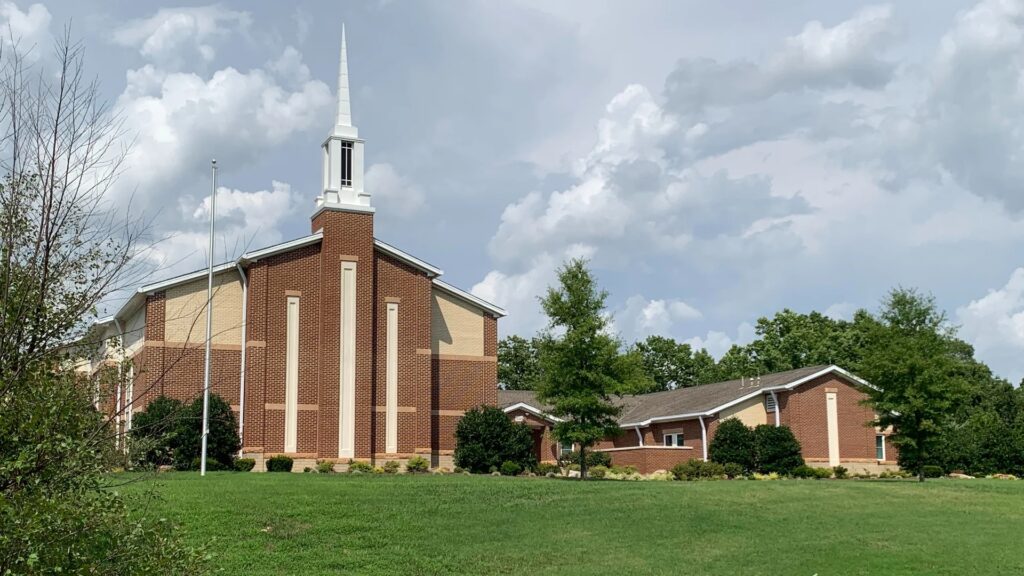 Exterior of The Church of Jesus Christ of Latter-day Saints in Brentwood, Tennessee, with a brick chapel and white steeple.