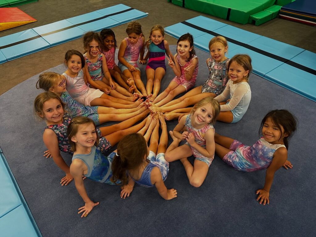 Children sitting together on gymnastics mats during a class at My Gym Brentwood in Tennessee.