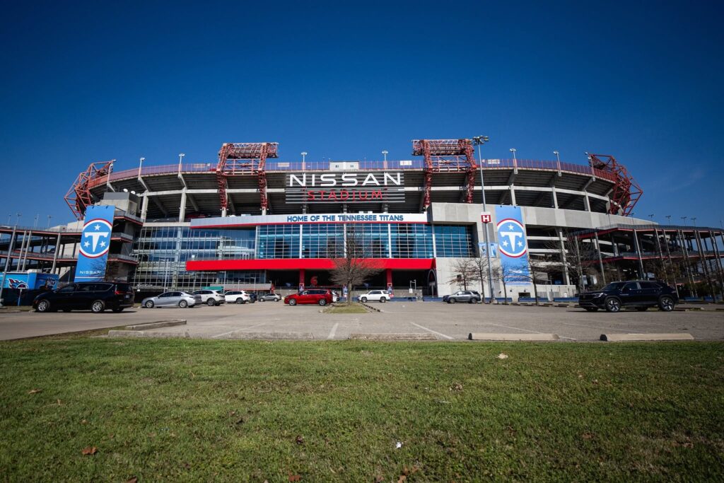 Exterior of Nissan Stadium in Nashville, Tennessee, with Tennessee Titans signage and parking areas in front.