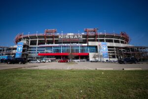 Exterior of Nissan Stadium in Nashville, Tennessee, with Tennessee Titans signage and parking areas in front.