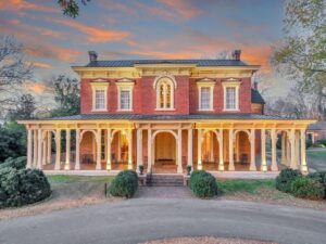 Front exterior of Oaklands Mansion in Murfreesboro, Tennessee, with its brick façade, wraparound porch, and landscaped grounds.