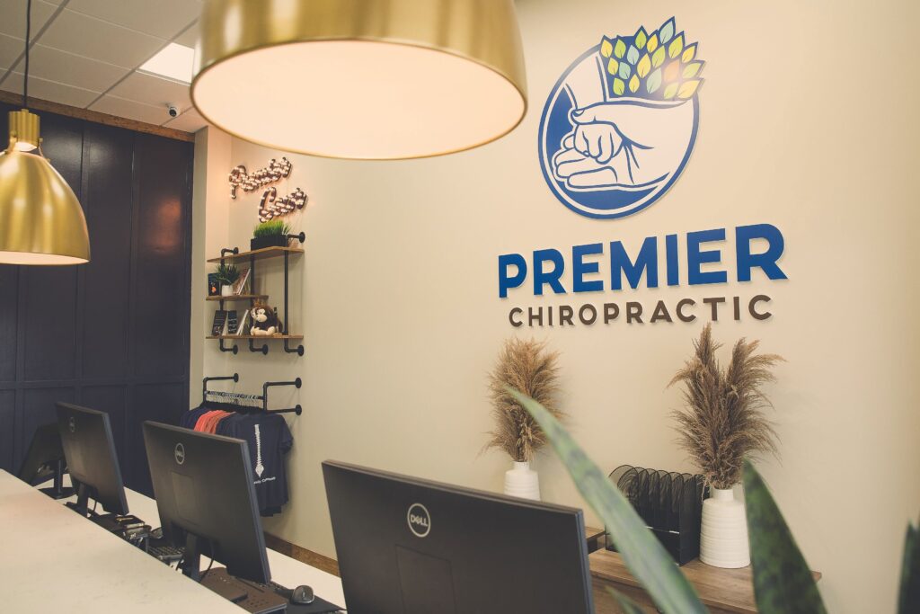 Reception area at Premier Chiropractic in Spring Hill, Tennessee, with the practice logo displayed on the wall.