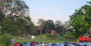 Visitors gathered on the lawn at Red Caboose Park in Bellevue, Nashville, with the park’s red train caboose visible nearby.