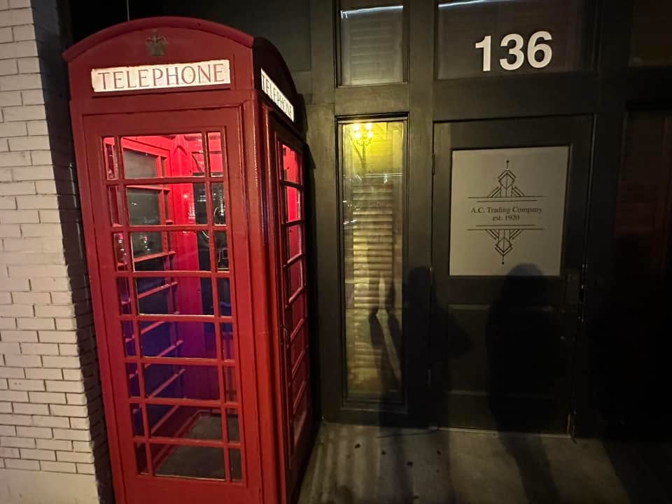Red British-style telephone booth outside the entrance to Red Phone Booth in downtown Nashville, Tennessee.