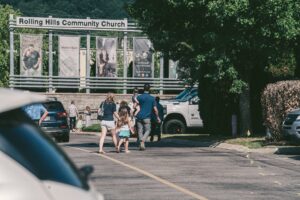 Families arriving at Rolling Hills Community Church in Franklin, Tennessee, near the church entrance and campus signage.