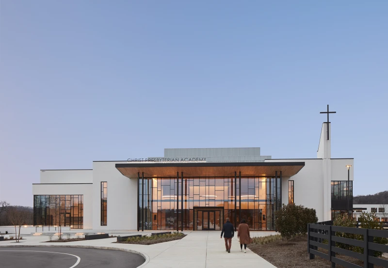 Exterior of the Soli Deo Center at Christ Presbyterian Academy in Nashville with a modern glass entrance and church cross.