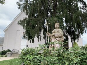 Exterior of St. Philip Catholic Church in downtown Franklin, Tennessee, with a statue of St. Philip near the church entrance.