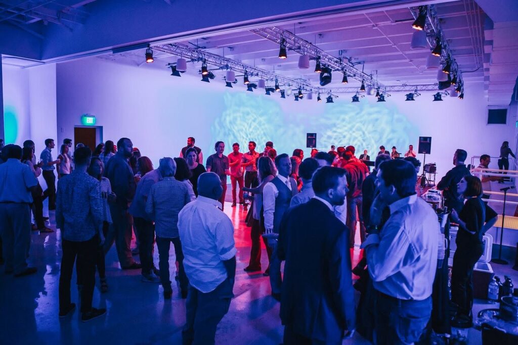 Guests gathered inside The Biltmore Garage at Studio 615 in Nashville with colorful event lighting and an open floor plan.