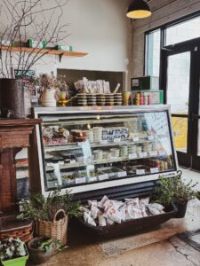 Interior of The Bottega at Frankies in Nashville with a refrigerated case displaying Italian meats, cheeses, prepared foods, and specialty items.