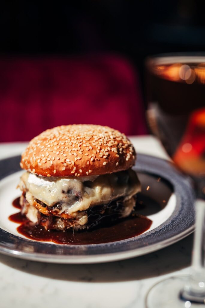 Cheeseburger served at The Electric Jane in Nashville, Tennessee, with a sesame seed bun and rich sauce.