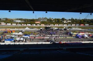 The Fairgrounds Nashville event complex with crowds, vendor tents, and an outdoor stage near the Nashville Fairgrounds Speedway.