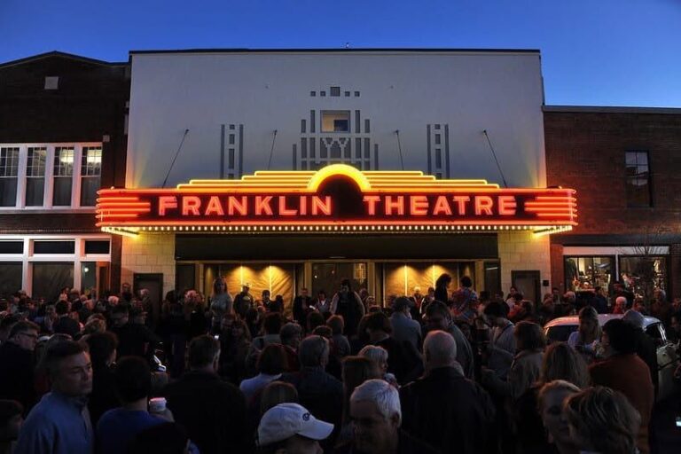 Crowd gathered outside The Franklin Theatre in downtown Franklin, Tennessee, beneath its illuminated marquee.