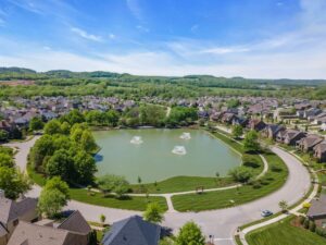 Aerial view of Tollgate Village in Thompson’s Station, Tennessee, with homes surrounding a neighborhood lake and walking paths.