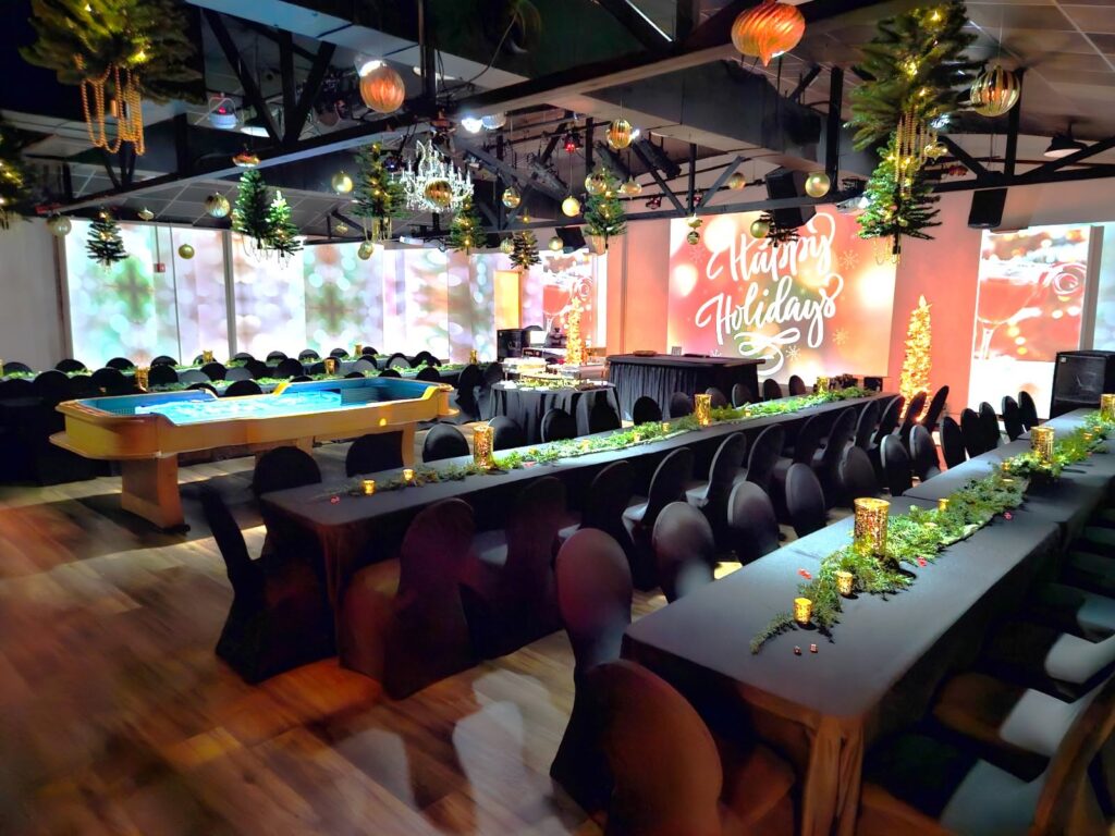 Walnut House event venue in Murfreesboro, Tennessee, decorated for a holiday gathering with banquet tables, greenery, and projected displays.