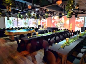 Walnut House event venue in Murfreesboro, Tennessee, decorated for a holiday gathering with banquet tables, greenery, and projected displays.
