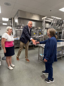 Jason Golden meets cafeteria staff member Linda Bruce at Freedom Intermediate School during a tour of the school with Food and Culinary Supervisor Robbin Cross