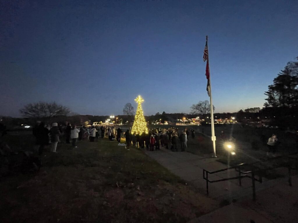 Crowd gathered around the lit Christmas tree at Fairview City Hall