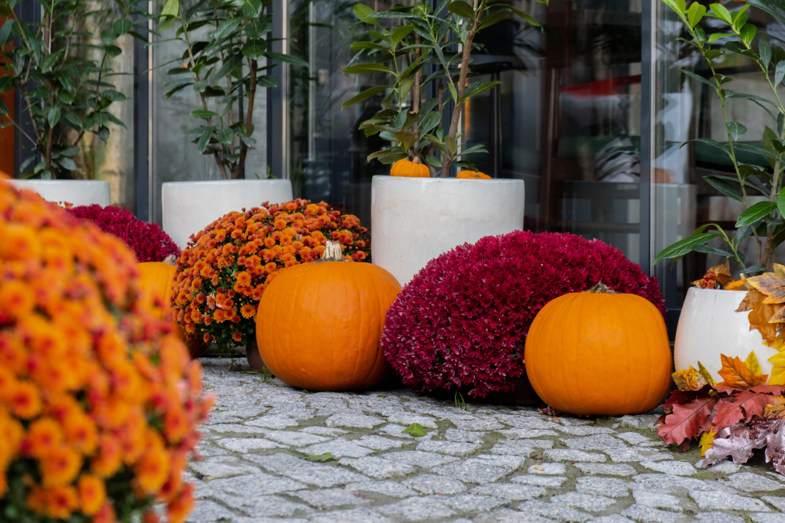 Fall front porch decorated with pumpkins, hay bales, lanterns, a wreath, and autumn garland in Franklin, TN
