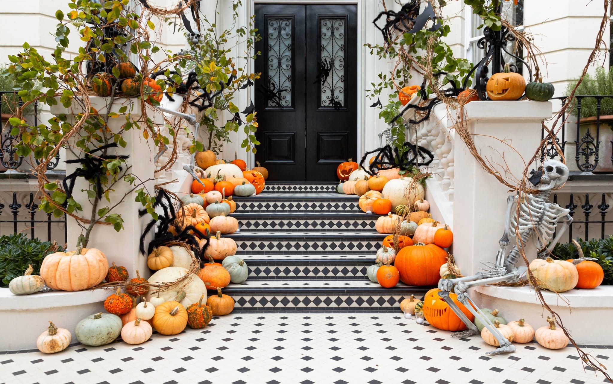 Fall porch decorated with pumpkins, jack-o’-lanterns, vines, and Halloween accents by The Pumpkin Veranda in Franklin, TN