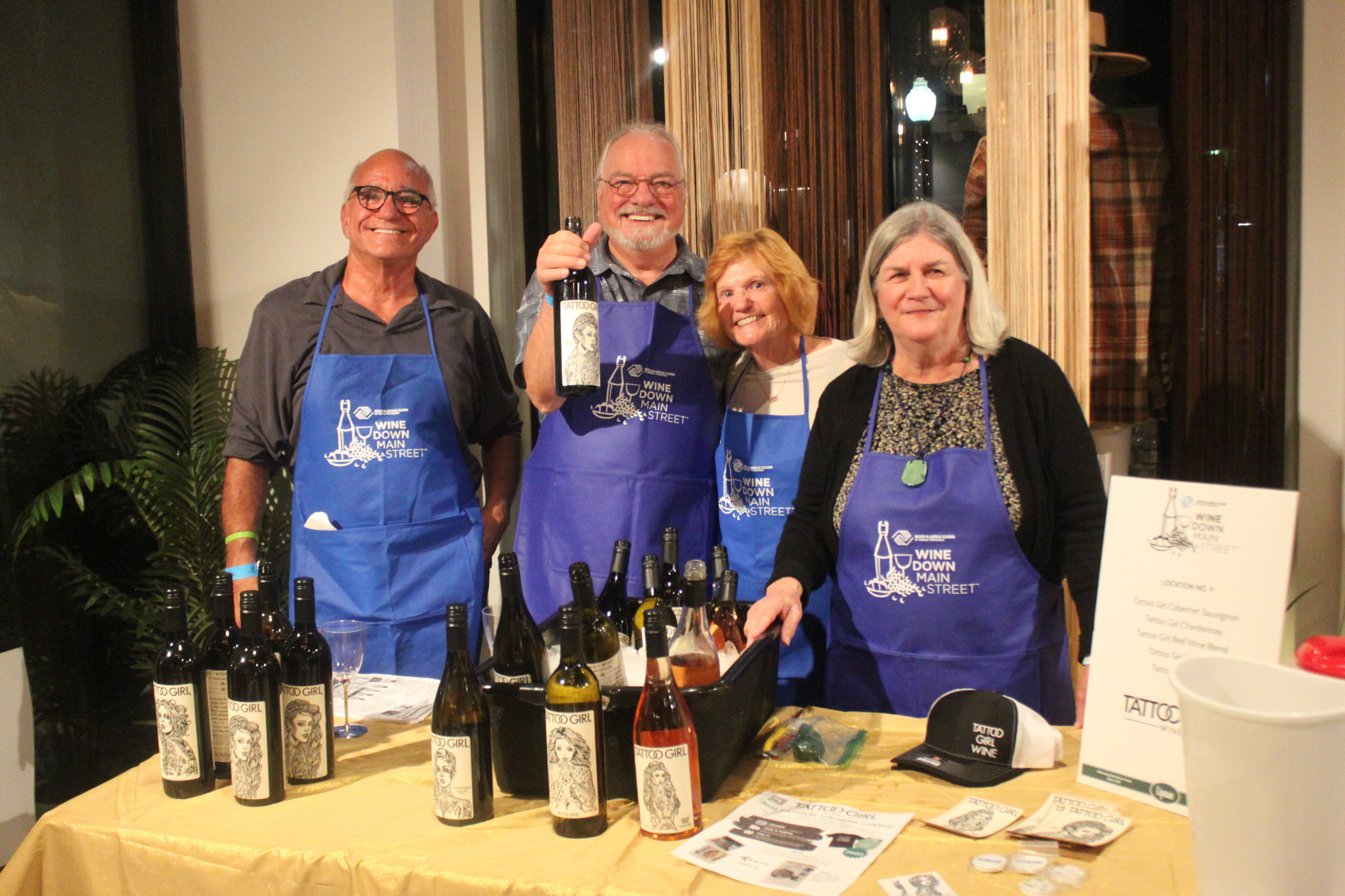 Wine Down Main Street in historic downtown Franklin, TN, wine samples and wine bottles on a table with friendly people smiling and standing behind the wine.