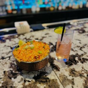 Indian rice dish and a cocktail served at Aha Indian Grill.