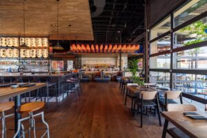 Interior of Blue Sushi Sake Grill at McEwen Northside in Franklin, Tennessee, with dining tables, bar seating, and Japanese-style lanterns.