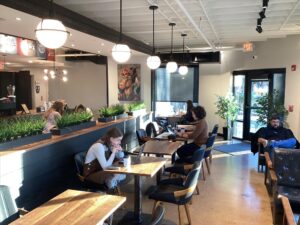 Interior of The Fainting Goat Coffee Co. in Franklin, Tennessee, with café tables, lounge seating, and customers working on laptops.