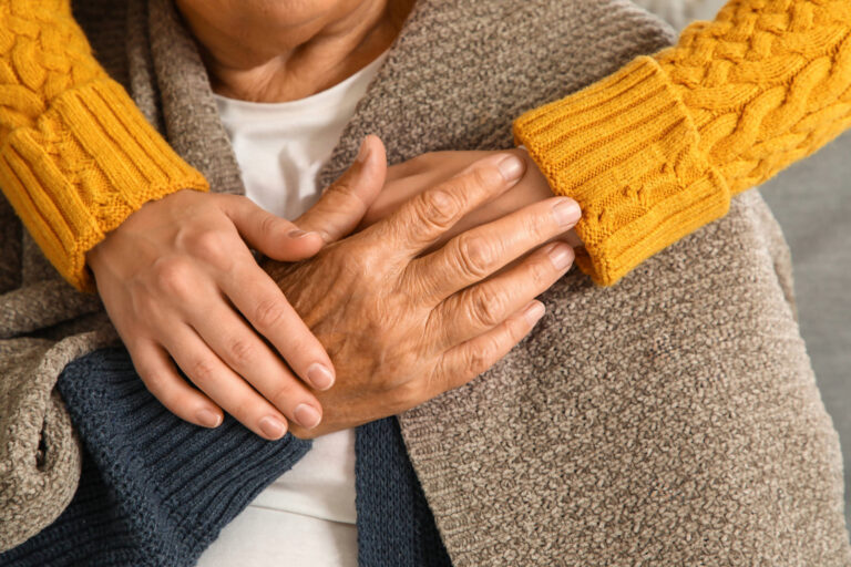 Caregiver holding an older adult's hands, illustrating the support and protection offered through the Home Safe Franklin program.