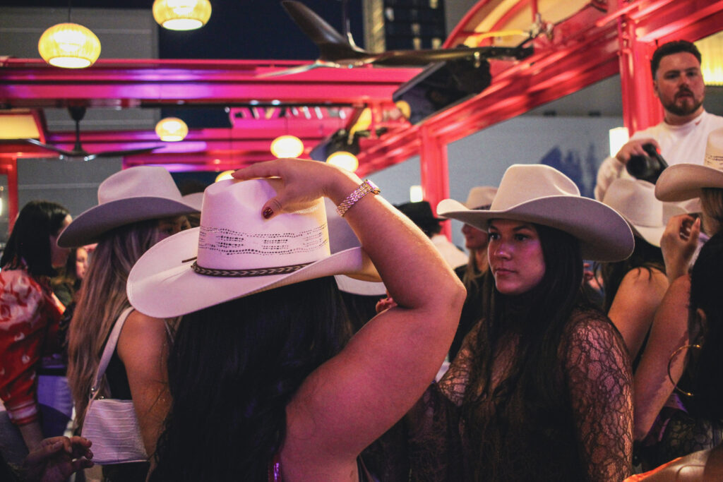 Guests at Puesto trying on cowgirl hats on the outdoor patio in Nashville Yards, Nashville, TN.
