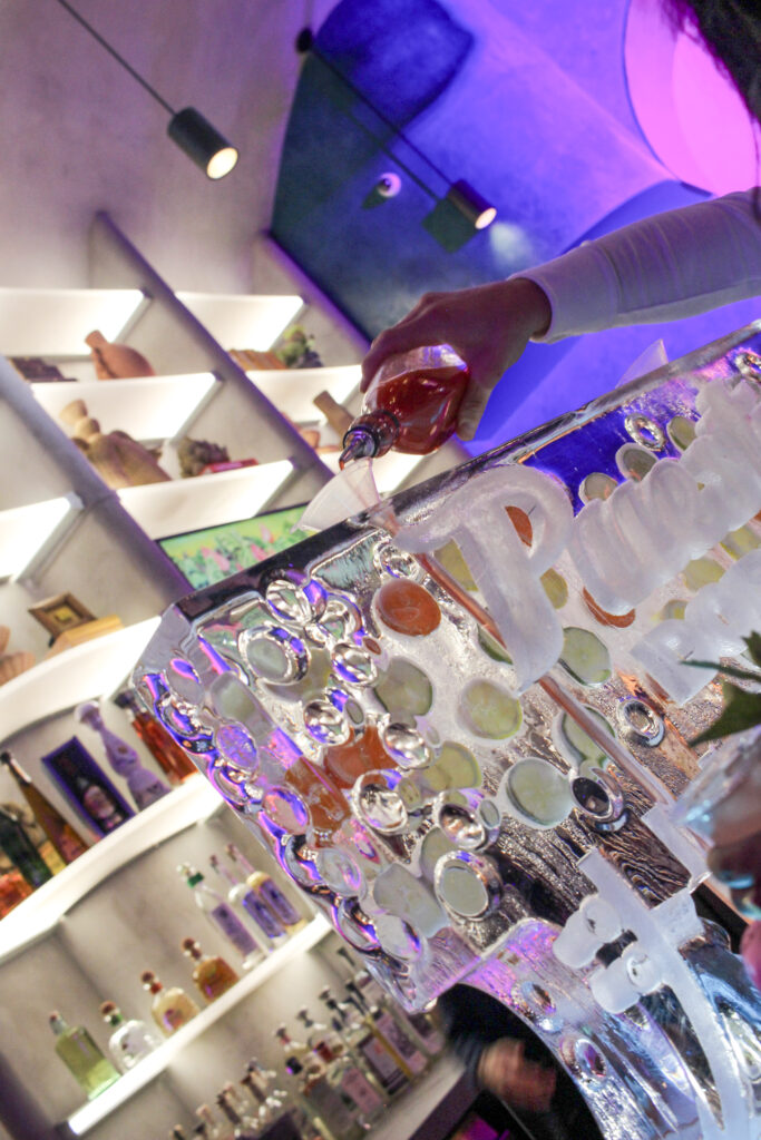 Bartender pouring a shot into an ice luge at Puesto Mexican restaurant in Nashville Yards, Nashville, TN.