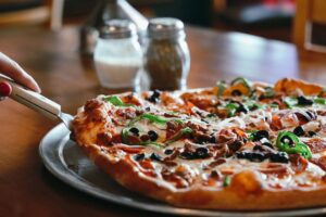 Fresh pizza topped with peppers, olives, cheese, and other ingredients at Sal’s Family Pizza in Brentwood, Tennessee.